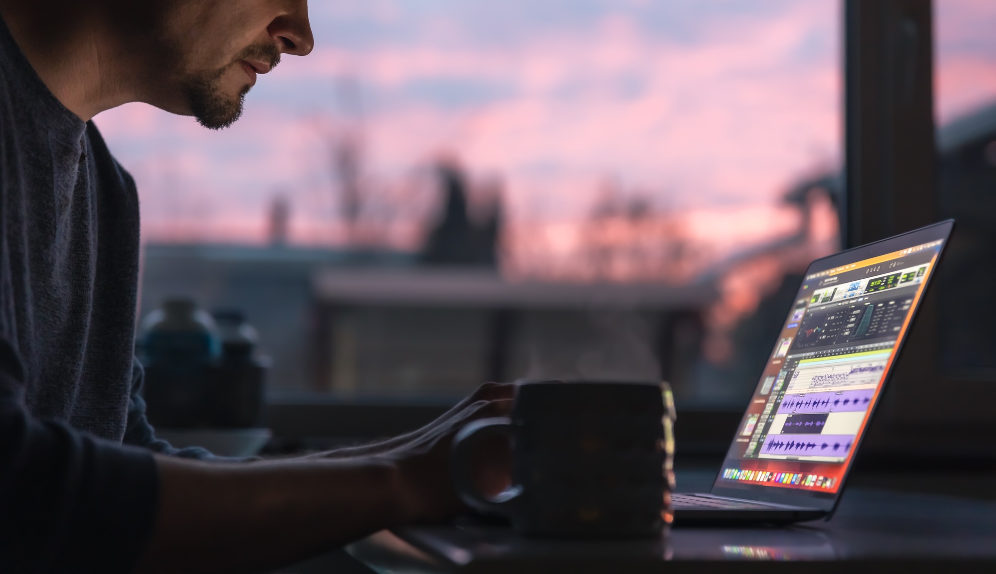 A man works with sound on a laptop early in the morning.
